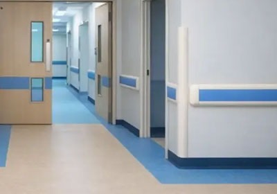 Empty hospital hallway with blue accented doors.
