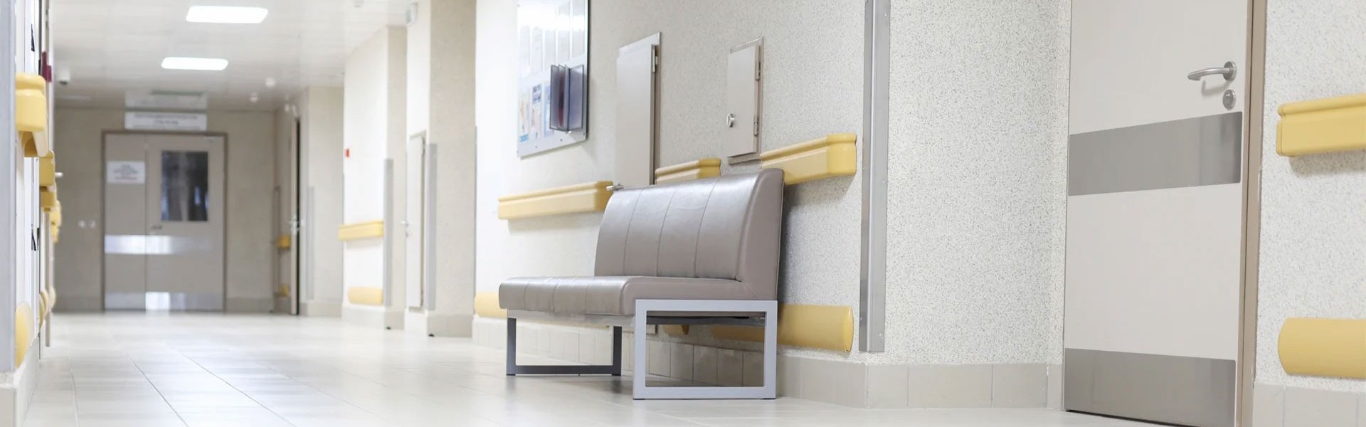 Modern empty hospital hallway with a waiting bench.